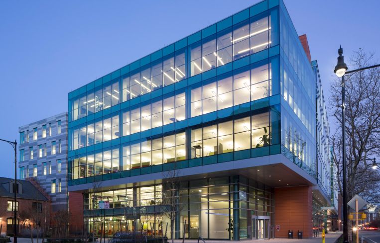 A squat, squarish office building illuminated at night.