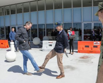 California Gov. Gavin Newsom, left, greets Los Angeles Mayor Gavin Newsom while practice social distancing.