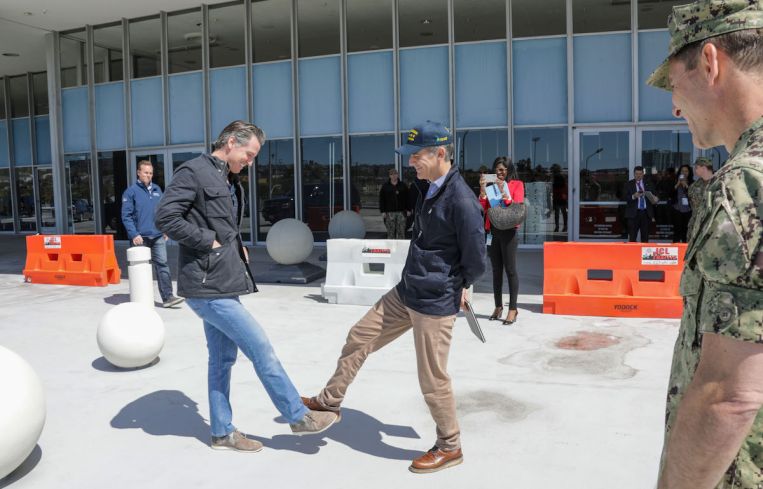 California Gov. Gavin Newsom, left, greets Los Angeles Mayor Gavin Newsom while practice social distancing.