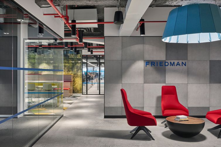 More primary colors in an open meeting space with red chairs and a blue light fixture.