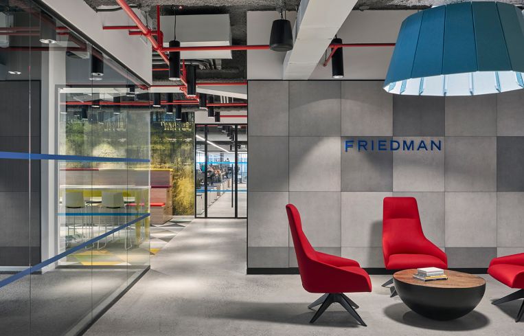 More primary colors in an open meeting space with red chairs and a blue light fixture.