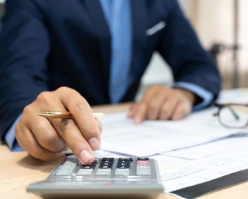 Hands of bank officer calculating loans.