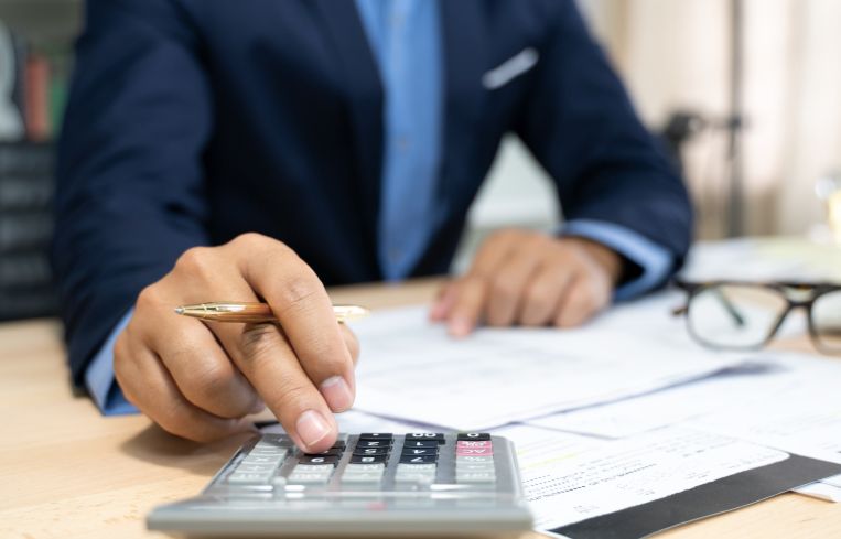 Hands of bank officer calculating loans.