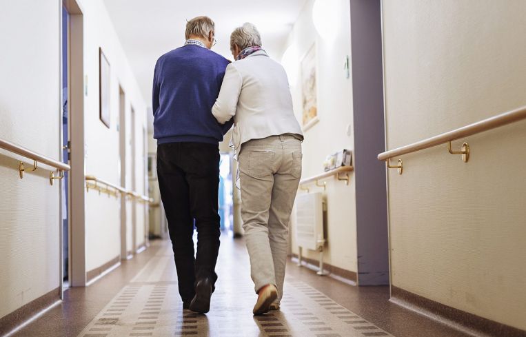 Senior Couple walking in a senior home.