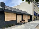 Buck Mason at 107 North Larchmont Boulevard has its windows and doors boarded up.