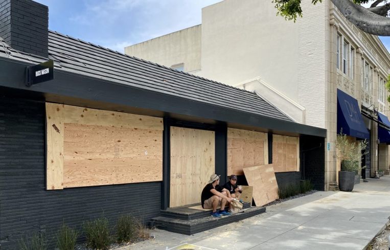 Buck Mason at 107 North Larchmont Boulevard has its windows and doors boarded up.