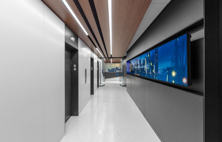 This wood-like paneling in the elevator lobby and reception area is in fact a silk screen applied to sheet rock. The architects used it to save money and trees.