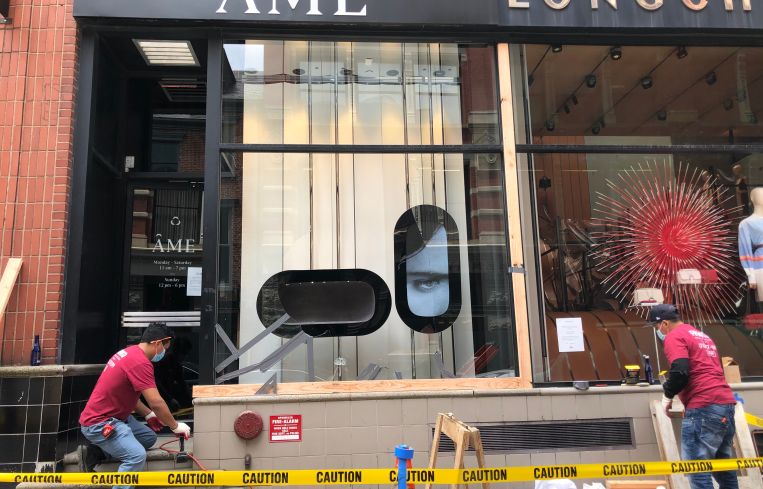 Workers boarding up the exterior of a jewelry store in Soho.