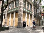 Officers protect a boarded up boutique on Spring Street in Soho on June 1, after the George Floyd protests turned violent the night before.