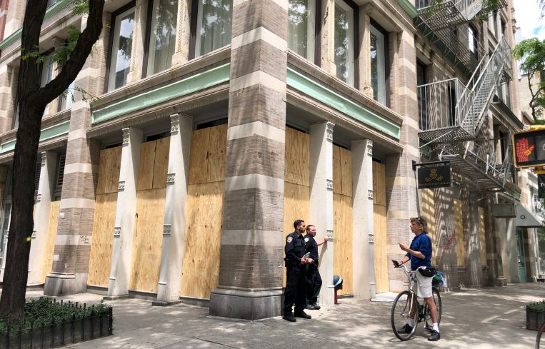 Officers protect a boarded up boutique on Spring Street in Soho on June 1, after the George Floyd protests turned violent the night before.