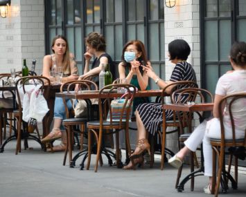 The federal unemployment rate has fallen as New York and other states reopen after coronavirus-induced business closures. Here, masked New Yorkers sit outside at The Smith on the Upper East Side.