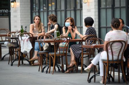 The federal unemployment rate has fallen as New York and other states reopen after coronavirus-induced business closures. Here, masked New Yorkers sit outside at The Smith on the Upper East Side.
