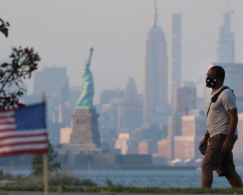 NEW YORK, NY - JULY 04: A citizen wearing a face mask walks by a beach on Independence Day on July 4, 2020 in New York City. Americans across the country celebrated Independence Day amid the spread of the coronavirus (COVID-19) pandemic. (Photo by Liao Pan/China News Service via Getty Images)