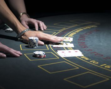 Two women playing Blackjack at gaming table, close-up