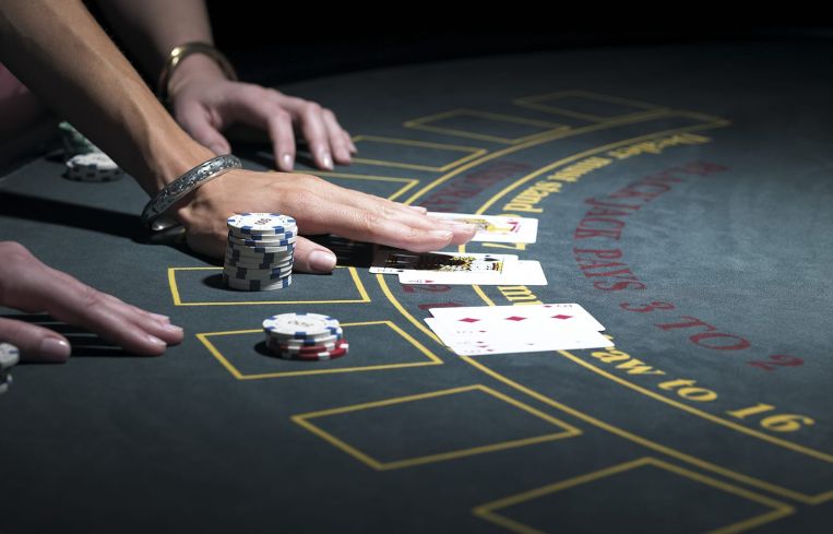 Two women playing Blackjack at gaming table, close-up