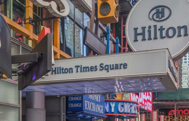 A colorful, busy hotel entrance on a sidewalk.