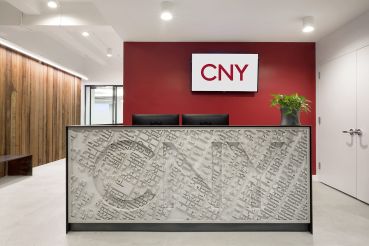 CNY Group designed a concrete reception desk that's been stamped with an aerial map of Midtown Manhattan and the company's name.