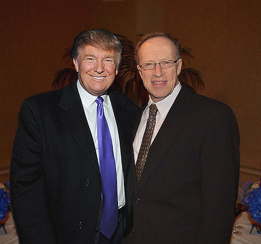 Two men standing side by side for a photo and smiling.