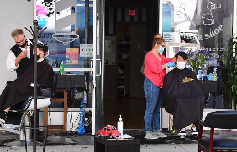 Hairdressers work on customers outdoors in L.A.