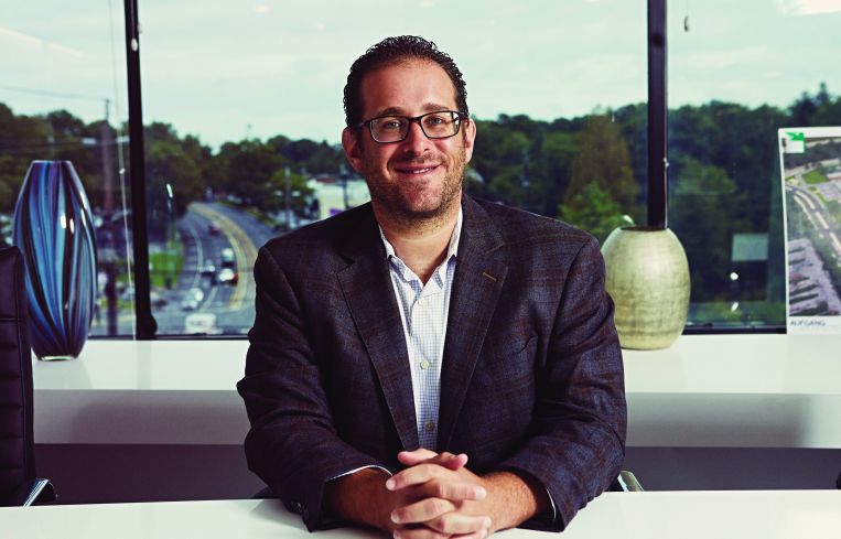 A man at a table with his hands folded.