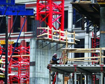 A construction worker on a construction site for a tall building.