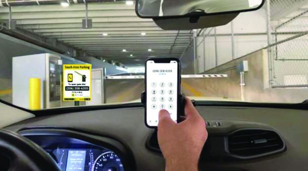 A rendering of someone holding up a cell phone as they enter a parking garage.