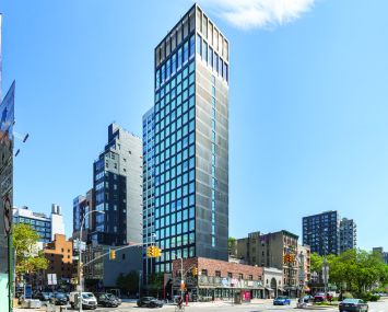 A wide shot of a tall, glassy building.