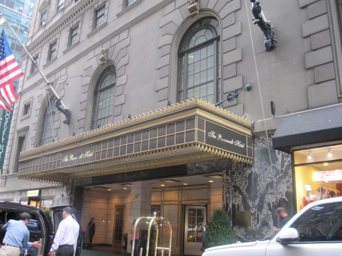 Entrance of a glitzy hotel on a sidewalk.