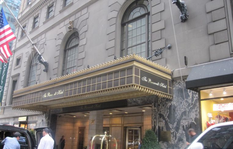 Entrance of a glitzy hotel on a sidewalk.