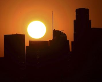 The sun sets behind Downtown Los Angeles on September 30. Third quarter office leasing dropped 18 percent from the second quarter.