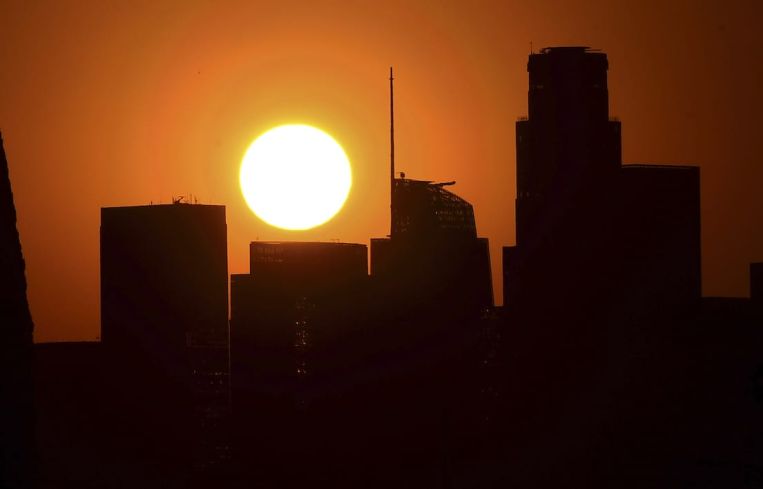 The sun sets behind Downtown Los Angeles on September 30. Third quarter office leasing dropped 18 percent from the second quarter.