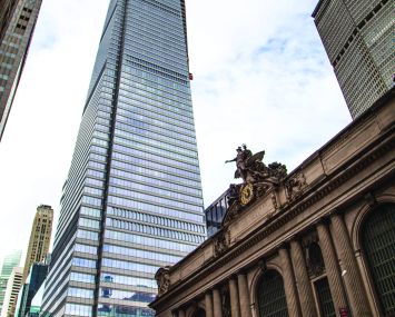 A glassy building viewed from far away on the street.