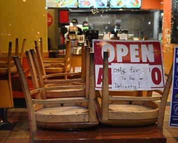 Employees work in a restaurant open for to-go or delivery orders only in Burbank in L.A. County. Outdoor dining for restaurants has been suspended in hopes of slowing a surge in Covid-19 cases. The measure has sparked a backlash from eateries and some county officials, who worry about the devastating economic toll.