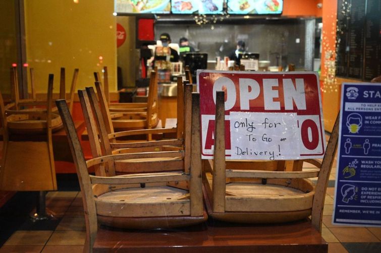 Employees work in a restaurant open for to-go or delivery orders only in Burbank in L.A. County. Outdoor dining for restaurants has been suspended in hopes of slowing a surge in Covid-19 cases. The measure has sparked a backlash from eateries and some county officials, who worry about the devastating economic toll.