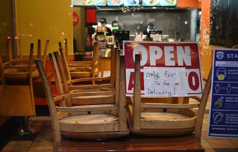 Employees work in a restaurant open for to-go or delivery orders only in Burbank in L.A. County. Outdoor dining for restaurants has been suspended in hopes of slowing a surge in Covid-19 cases. The measure has sparked a backlash from eateries and some county officials, who worry about the devastating economic toll.