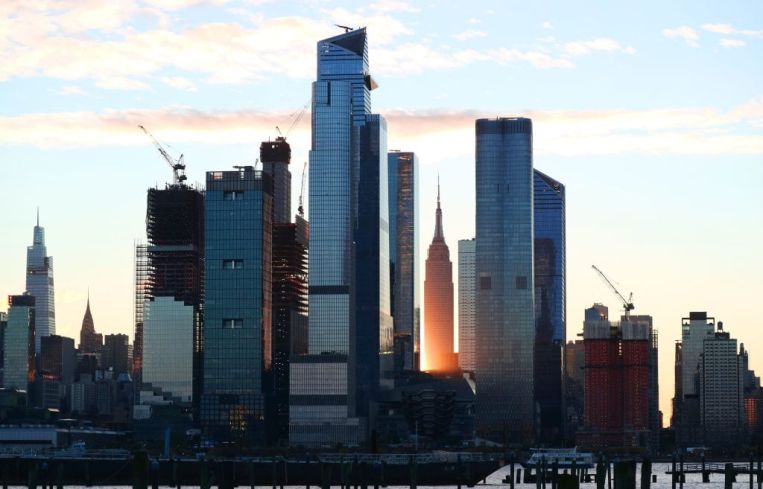 A photo of very tall buildings collected against a sunset.
