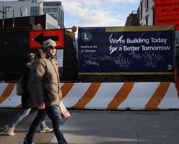 Pedestrians cross in front of some of the repair work to the L line in January 2019.