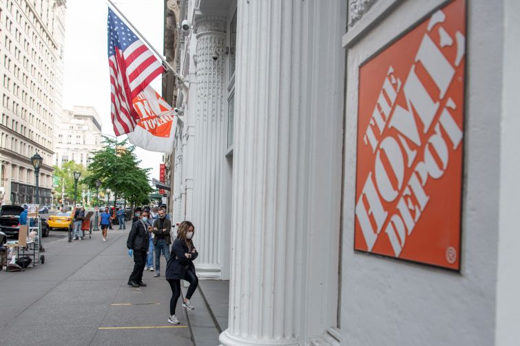 The outside of a store on a busy city street, and the outside has a sign that says "Home Depot."