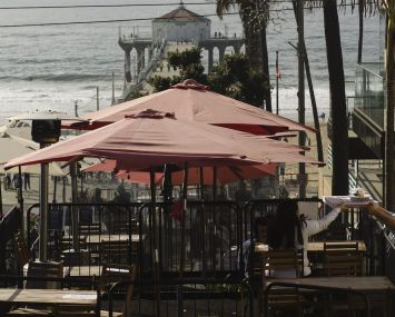 People eat takeout food at a "public parklet" due to COVID-19 restrictions on restaurant outdoor dining in Manhattan Beach, Calif.