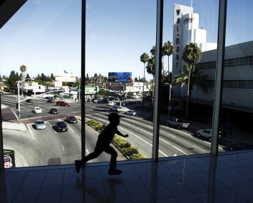 A child runs across a pedestrian bridge connecting separate parts of the Baldwin Hills Crenshaw Plaza shopping center in 2015. Another pending nine-figure deal for the landmark shopping mall has again been terminated this year due to community pressure.