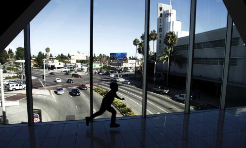 A child runs across a pedestrian bridge connecting separate parts of the Baldwin Hills Crenshaw Plaza shopping center in 2015. Another pending nine-figure deal for the landmark shopping mall has again been terminated this year due to community pressure.