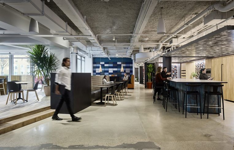 The main common spaces are somewhat industrial, with polished concrete floors and open ceilings painted gray.