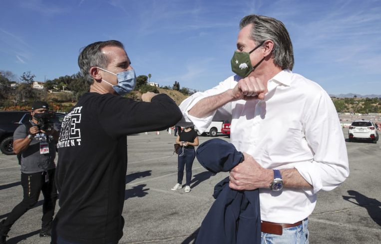 Los Angeles Mayor Eric Garcetti, left, greets California Governor Gavin Newsom at the launch of mass Covid-19 vaccination site at Dodger Stadium on January 15.
