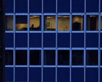 Shot of a building, with one floor illuminated and another one dark.
