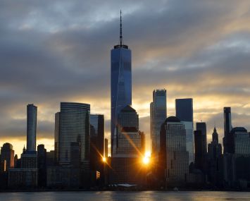 A skyline at sunset with several tall buildings.
