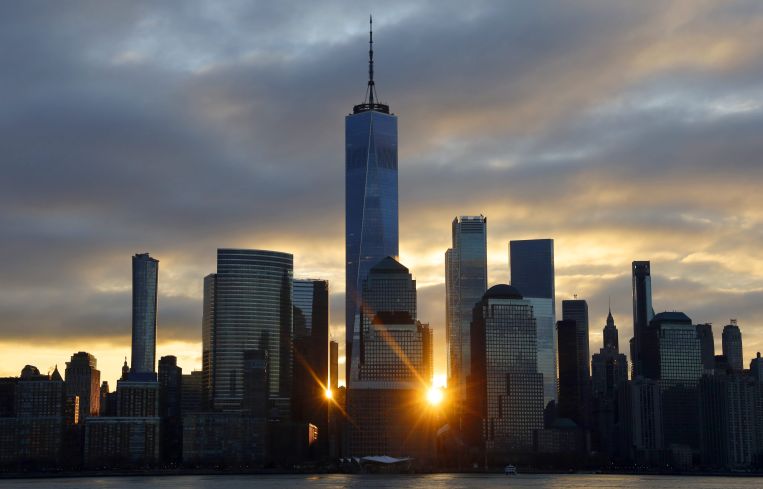 A skyline at sunset with several tall buildings.