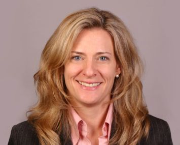 A woman with long hair smiling into the camera.