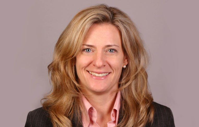 A woman with long hair smiling into the camera.