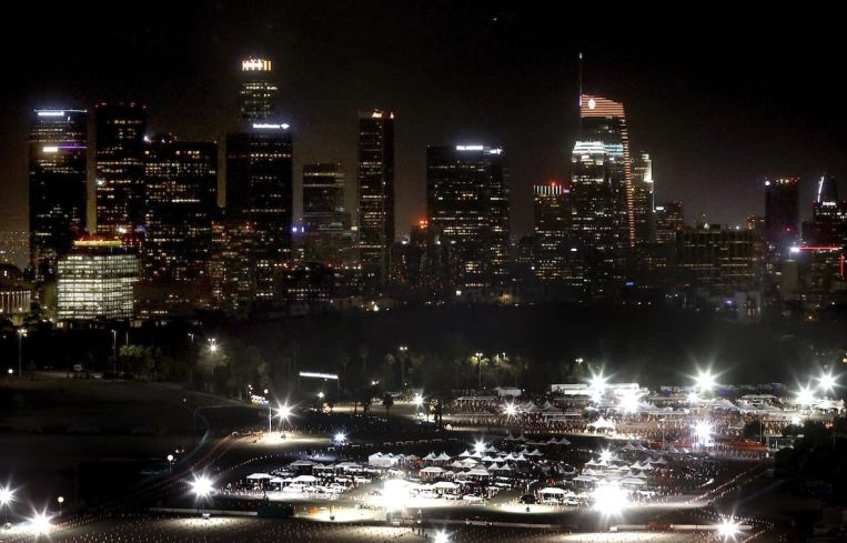 The Dodger Stadium testing and vaccination site overlooked by Los Angeles' skyline.