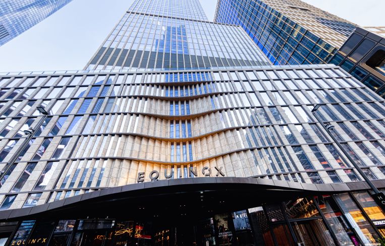 The exterior of a tall, glass building looking up at it closely.